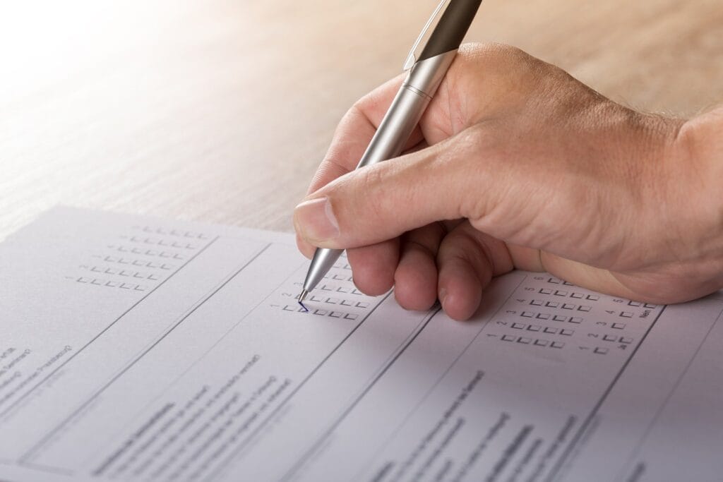 A person filling in a paper survey.